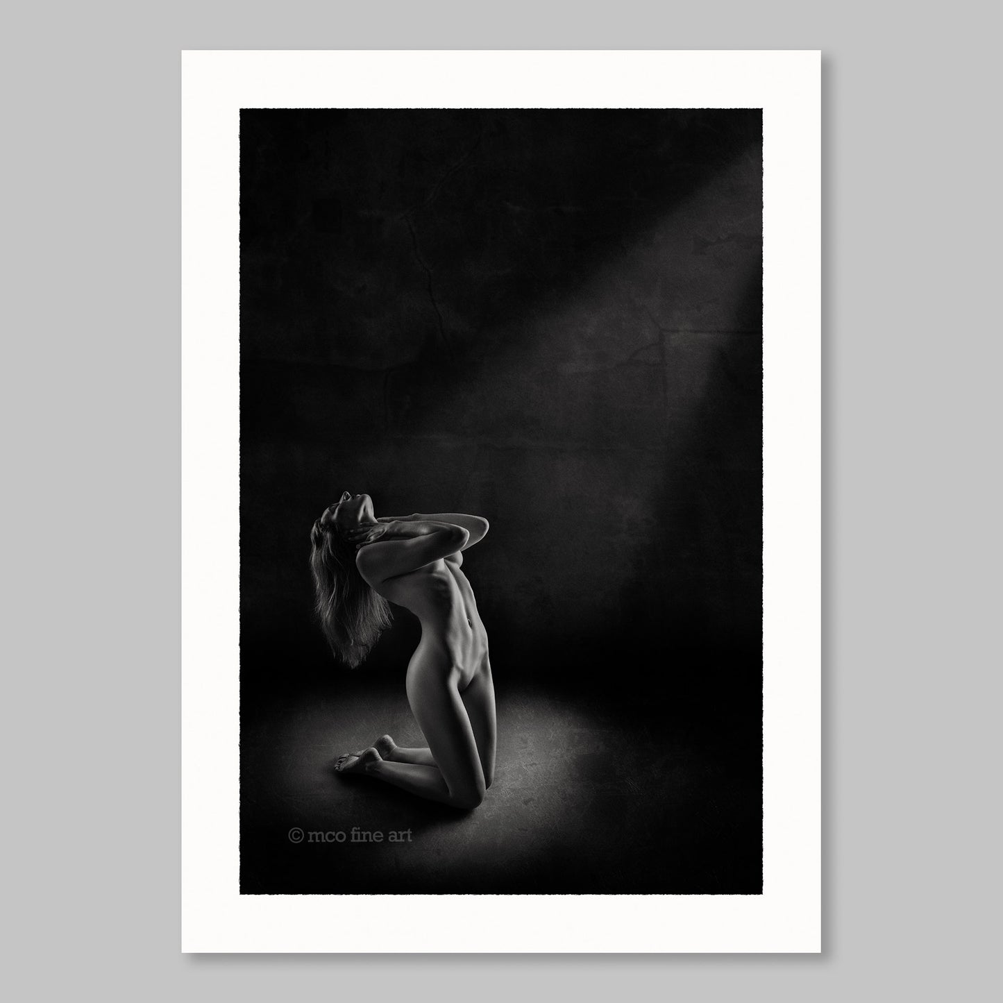Black and white fine art photograph of a nude figure in a dark setting.