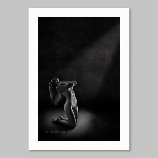 Black and white fine art photograph of a nude figure in a dark setting.