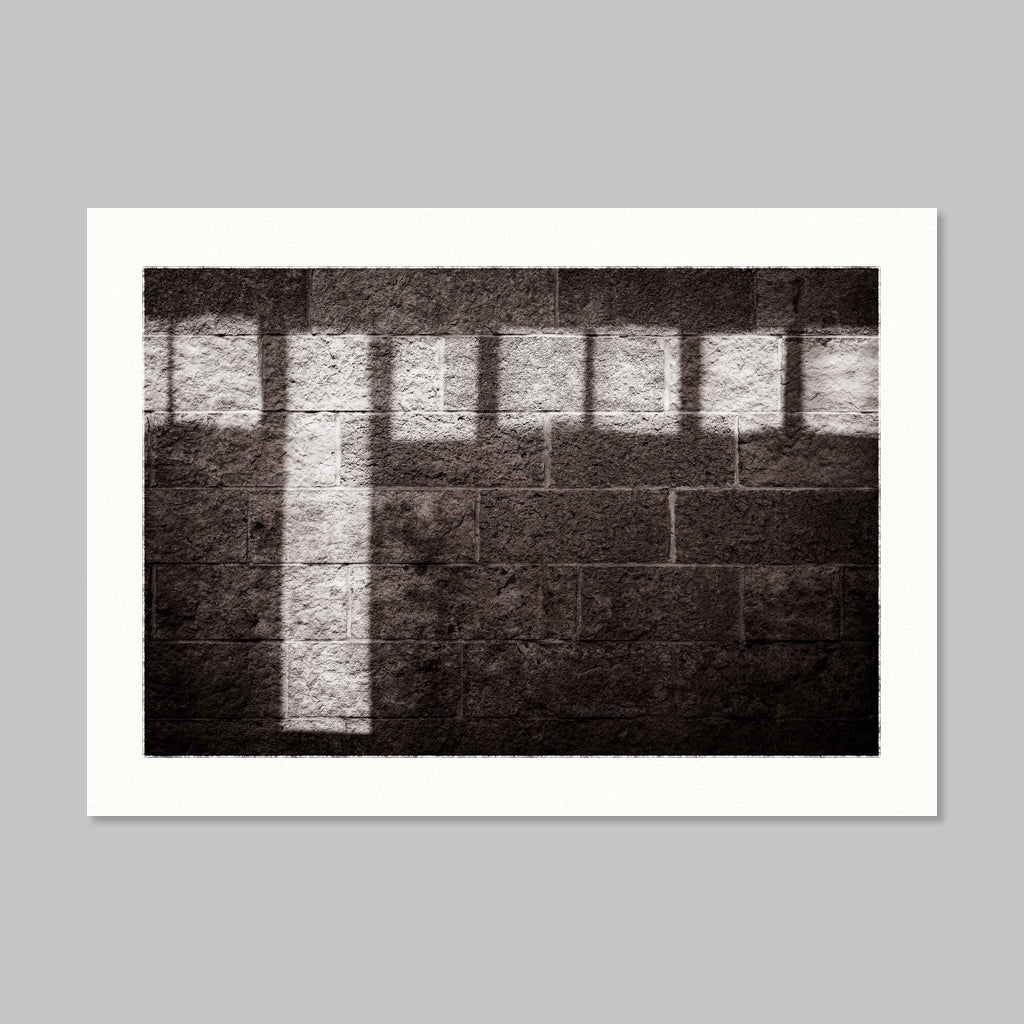 Monochrome photo of sunlight reflections on a stone wall.